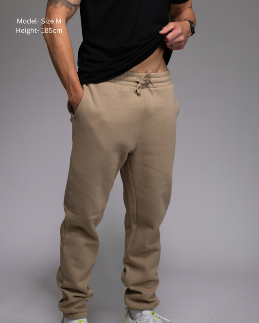 STRYD Performance Elite Unisex Track Pant in Sand — front view on male model, relaxed regular fit, elasticated waistband | Premium 320GSM fleece activewear Australia, Sunshine Coast
activewear and gym wear Queensland, fast shipping within 24hrs of order and free shipping when you spend $150 AUD, Tracksuit pants, athleisure winter sets, premium apparel