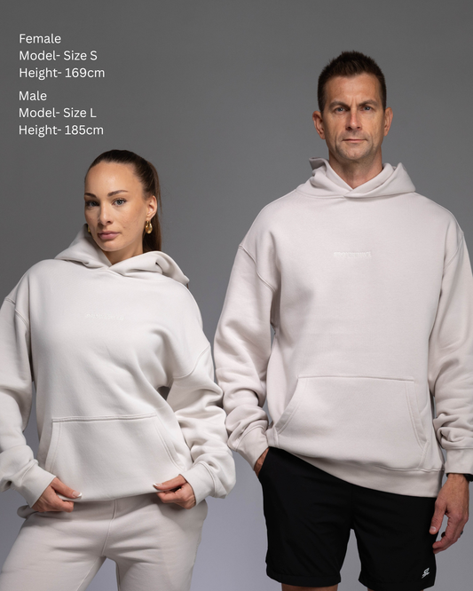 STRYD Performance Elite Unisex Hoodie in Bone — male female duo of models showing the unisex fit, relaxed boxy silhouette, self-fabric lined hood | Premium gym wear Australia