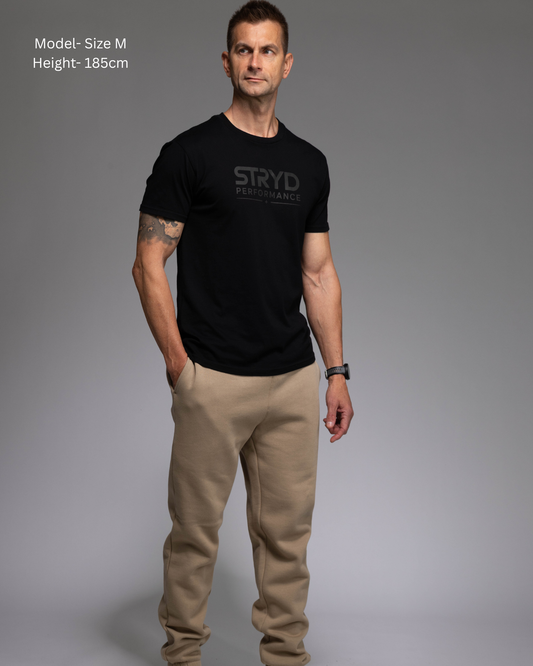STRYD Performance Elite Unisex Track Pant in Sand — front view on male model, relaxed regular fit, elasticated waistband | Premium 320GSM fleece activewear Australia, Sunshine Coast 
activewear and gym wear Queensland, fast shipping within 24hrs of order and free shipping when you spend $150 AUD, Tracksuit pants, athleisure winter sets, premium apparel