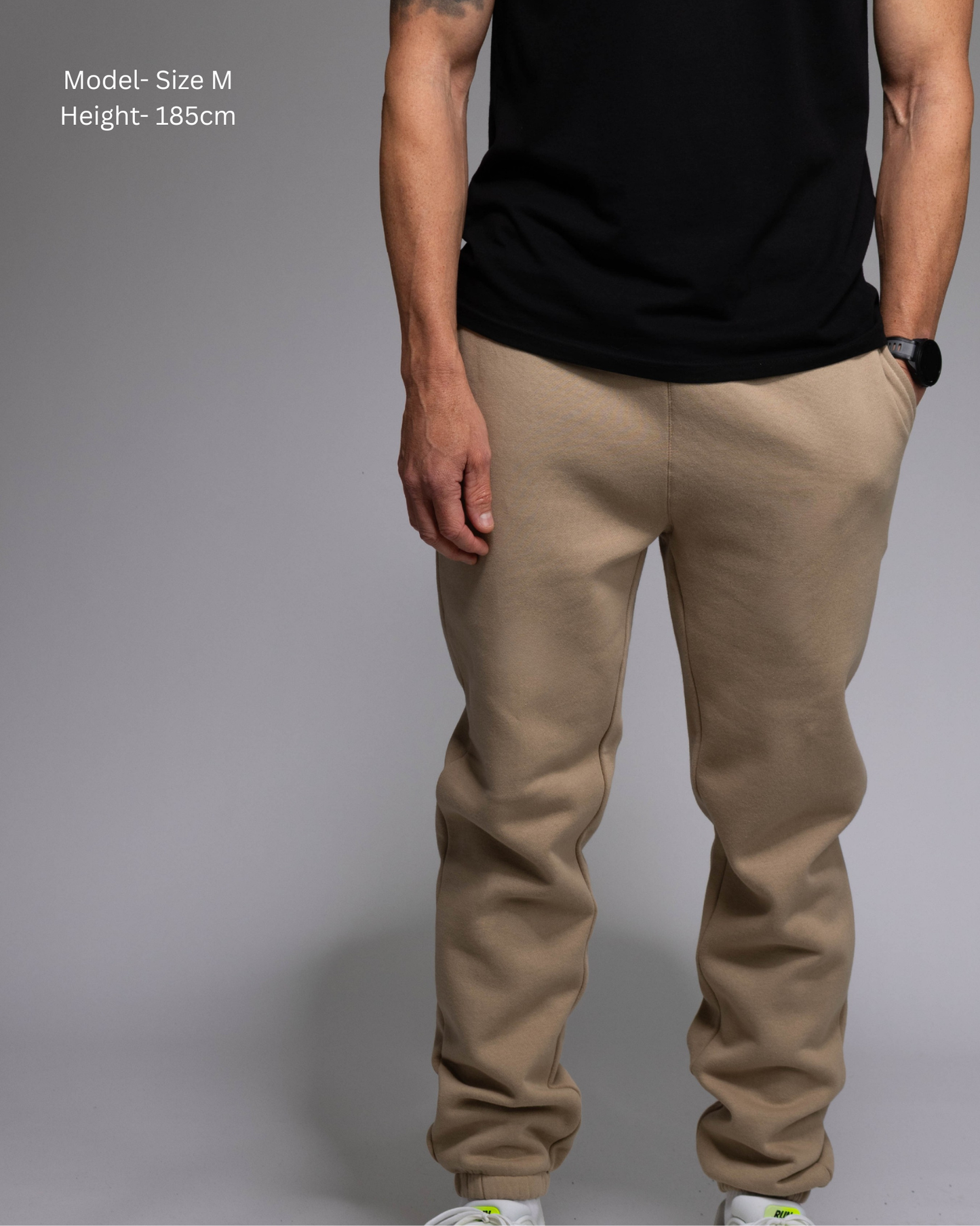 STRYD Performance Elite Unisex Track Pant in Sand — front view on male model, relaxed regular fit, elasticated waistband | Premium 320GSM fleece activewear Australia, Sunshine Coast 
activewear and gym wear Queensland, fast shipping within 24hrs of order and free shipping when you spend $150 AUD, Tracksuit pants, athleisure winter sets, premium apparel
