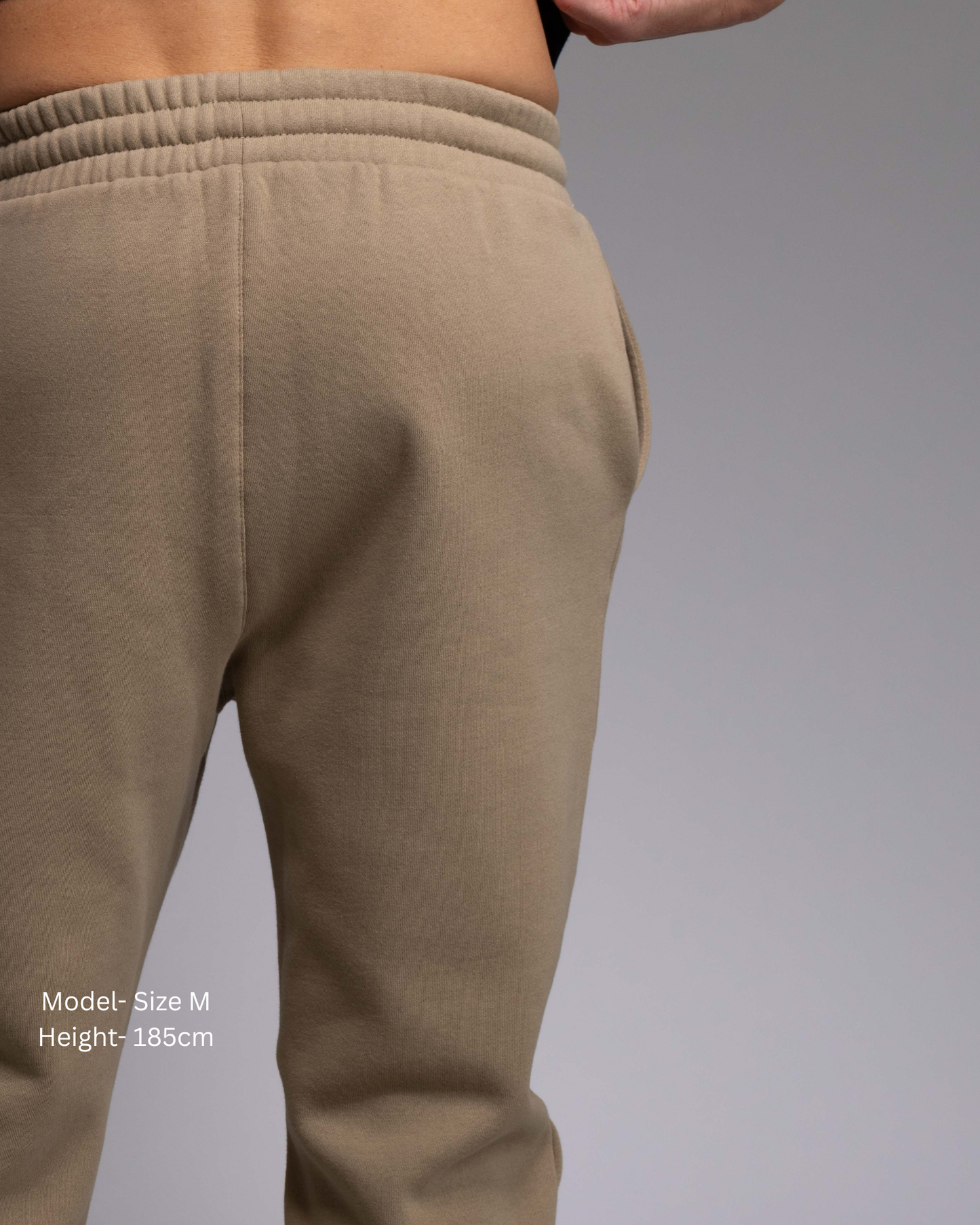STRYD Performance Elite Unisex Track Pant in Sand —back view on male model, relaxed regular fit, elasticated waistband | Premium 320GSM fleece activewear Australia, Sunshine Coast 
activewear and gym wear Queensland, fast shipping within 24hrs of order and free shipping when you spend $150 AUD, Tracksuit pants, athleisure winter sets, premium apparel