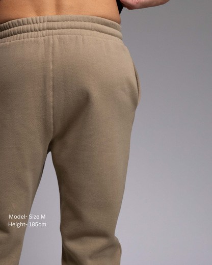 STRYD Performance Elite Unisex Track Pant in Sand —back view on male model, relaxed regular fit, elasticated waistband | Premium 320GSM fleece activewear Australia, Sunshine Coast 
activewear and gym wear Queensland, fast shipping within 24hrs of order and free shipping when you spend $150 AUD, Tracksuit pants, athleisure winter sets, premium apparel