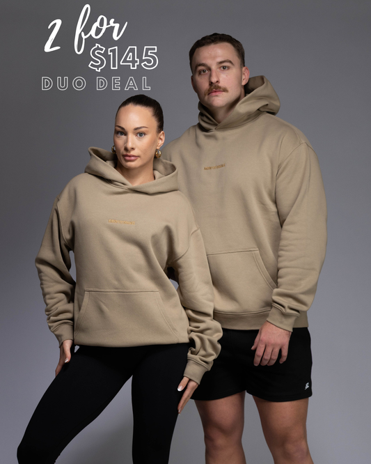 Premium Drop shoulder STRYD Performance Elite Unisex Hoodie in Sand — 320 GSM fleece, relaxed fit, drop-shoulder, ribbed cuffs, premium activewear Australia, Sunshine Coast activewear shop now free shipping over $150 Male and female models wearing sand coloured Elite Hoodies