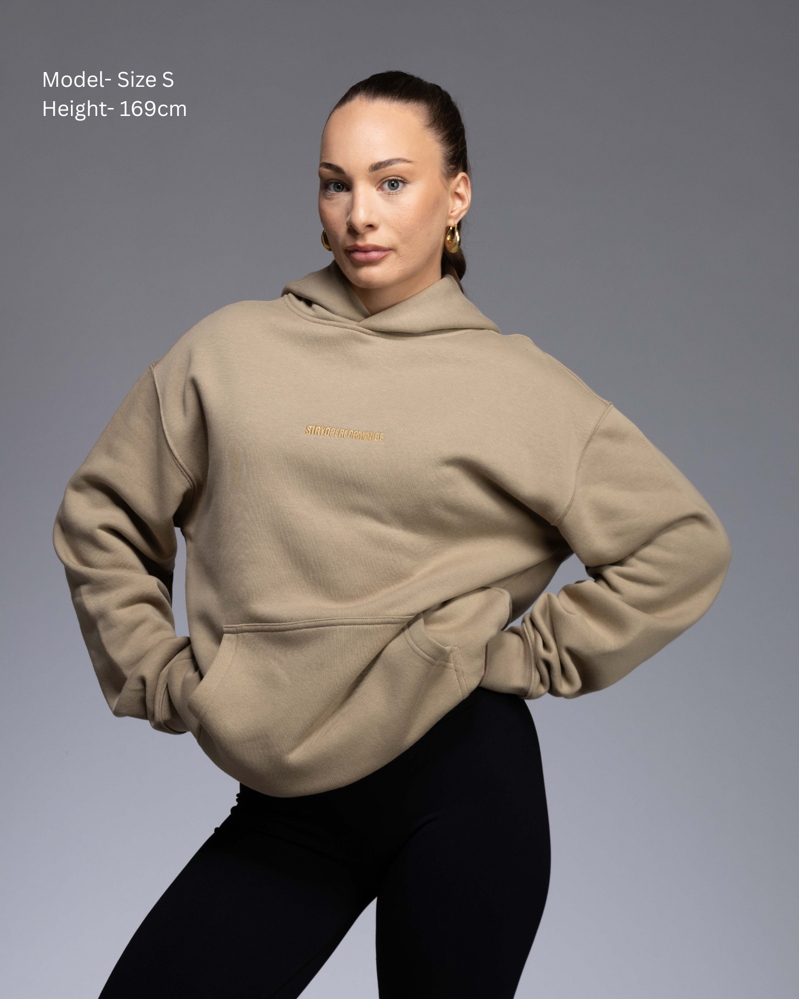 Premium Drop shoulder STRYD Performance Elite Unisex Hoodie in Sand — 320 GSM fleece, relaxed fit, drop-shoulder, ribbed cuffs, premium activewear Australia, Sunshine Coast activewear shop now free shipping over $150 Front View of Elite Hood Female Model