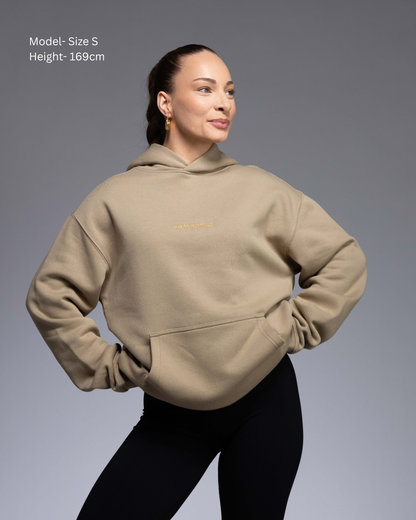 Premium Drop shoulder STRYD Performance Elite Unisex Hoodie in Sand — 320 GSM fleece, relaxed fit, drop-shoulder, ribbed cuffs, premium activewear Australia, Sunshine Coast activewear shop now free shipping over $150 Front View of Elite Hood Female Model