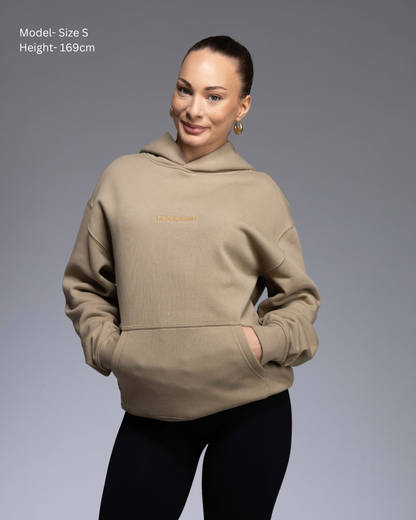 Premium Drop shoulder STRYD Performance Elite Unisex Hoodie in Sand — 320 GSM fleece, relaxed fit, drop-shoulder, ribbed cuffs, premium activewear Australia, Sunshine Coast activewear shop now free shipping over $150 Front View of Elite Hood Female Model