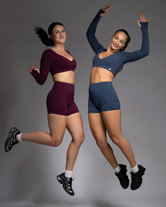 Two Women Jumping in Haven Matching Sets – Berry and Teal High-Rise Training Shorts and Sports Bra | STRYD Performance Activewear Sunshine Coast

