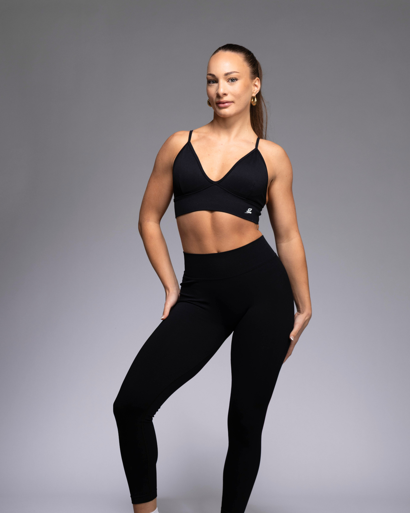 STRYD Performance Peaches push up sports top in black— Front view. Women's premium push up activewear top.
