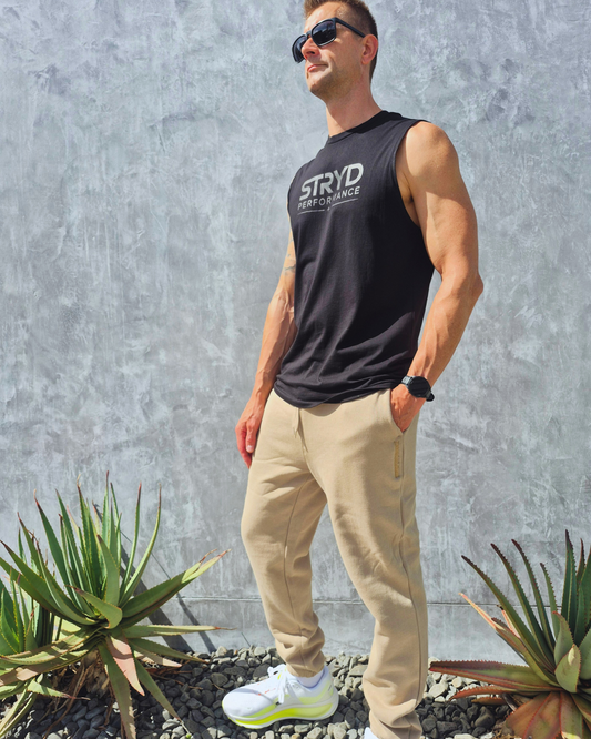 STRYD Performance Elite Unisex Track Pant in Sand — front view on male model, relaxed regular fit, elasticated waistband | Premium 320GSM fleece activewear Australia, Sunshine Coast 
activewear and gym wear Queensland, fast shipping within 24hrs of order and free shipping when you spend $140 AUD, Tracksuit pants, athleisure winter sets, premium apparel

